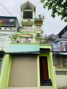 um edifício amarelo e verde com uma varanda em Su Homestay em Cao Bang