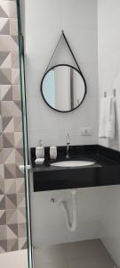 a bathroom with a sink and a mirror at Casa com piscina duas quadras da praia in Guaratuba