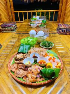 a table with a plate of food on a table at Lakeview Homestay Vu Linh in Yen Bai