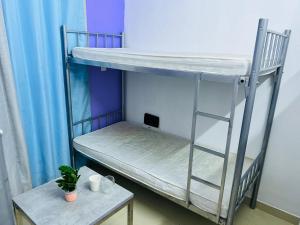 杜拜的住宿－Hostel Executive Bed Space Near Mall of the Emirates，一张桌子的房间里设有两张双层床