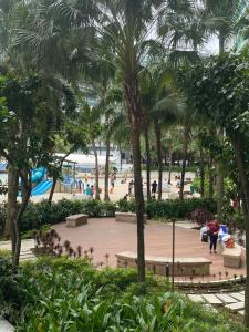 een park met palmbomen en mensen op het strand bij Azure Urban Suite Room in Manilla
