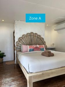 - une chambre avec un grand lit et une tête de lit en bois dans l'établissement Siam Beach Resort Koh Kood, à Ko Kood