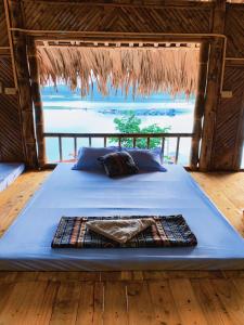 a bed in a room with a view of the ocean at Lakeview Homestay Vu Linh in Yen Bai