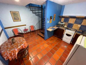 uma pequena cozinha com uma mesa e uma escada em El Sol Posada em San Cristóbal