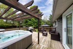a hot tub on a deck next to a house at Charming 3-Bed House with HotTub in Barrie