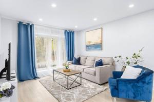 sala de estar con sofá y sillas azules en Charming 3-Bed House with HotTub, en Barrie