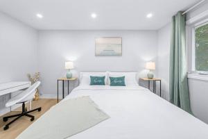 Biała sypialnia z dużym łóżkiem i biurkiem w obiekcie Charming 3-Bed House with HotTub w mieście Barrie