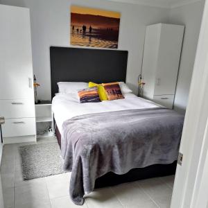 1 dormitorio con 1 cama grande con almohadas amarillas en Gumnut Getaway BnB en Goolwa North