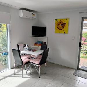 een eetkamer met een tafel en stoelen en een tv bij Gumnut Getaway BnB in Goolwa North