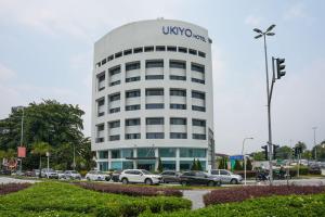 een uso kantoorgebouw met auto's geparkeerd op een parkeerplaats bij Ukiyo Hotel in Petaling Jaya