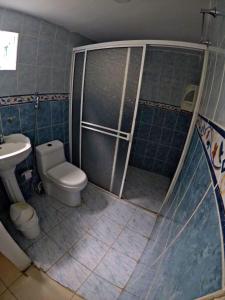 een kleine badkamer met een toilet en een douche bij Nahimara Champeta Hostel in Cartagena