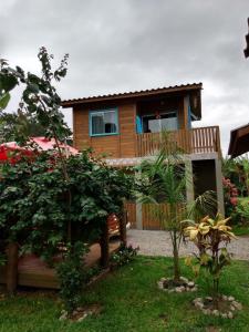 una casa con un jardín delante de ella en Cabanas do Lorde, en Praia do Rosa