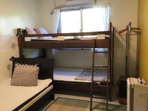 two bunk beds in a room with a window at Shimaotoya in Iriomote
