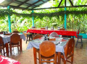 a restaurant with tables and chairs with red table cloth at Posada Río Celeste La Amistad in Rio Celeste