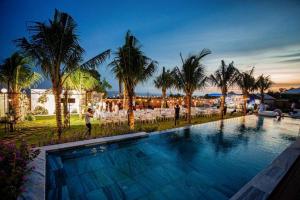 una gran piscina con palmeras en un complejo en Sunset Hill Villa Mũi Né en Phan Thiet