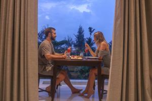 a man and a woman sitting at a table at Mzion Hotel Weligama in Weligama