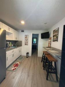 una cucina con armadietti bianchi e pavimenti in legno di Quiet & Centrally located House - PRIVATE PARKING, LAUNDRY AND STORAGE FOR LUGGAGE a Miami