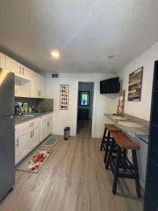 迈阿密Quiet & Centrally located House - PRIVATE PARKING, LAUNDRY AND STORAGE FOR LUGGAGE的配有白色橱柜和木地板的厨房