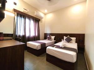 een hotelkamer met 2 bedden en een keuken bij HOTEL ELITE in Rāmeswaram