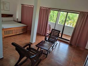 a bedroom with two chairs and a bed and a balcony at Villa piscina natural in Río San Juan