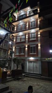 un hombre parado frente a un edificio por la noche en Badri Homes, en Pātan