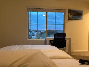 a bedroom with a bed and a desk and a window at Breeze Valley Homestay in Tucson