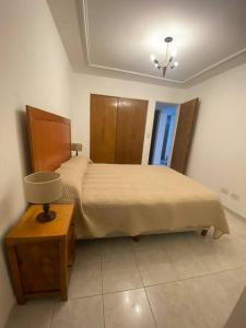 ein Schlafzimmer mit einem Bett und einer Lampe auf einem Tisch in der Unterkunft Alquiler departamento amoblado in Río Cuarto
