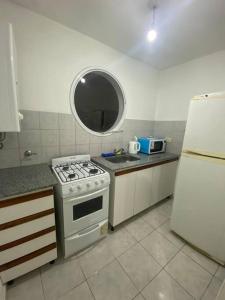 eine Küche mit einem Herd, einer Spüle und einem Kühlschrank in der Unterkunft Alquiler departamento amoblado in Río Cuarto