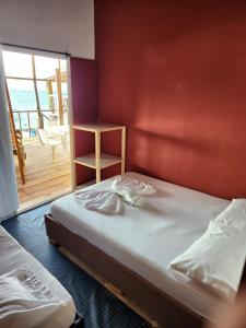 a bedroom with two beds and a balcony with the ocean at Palos Locos Baru in Cartagena de Indias