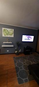un soggiorno con parete e TV a schermo piatto di Amplió, cómodo y amoblado departamento, La Florida a Santiago