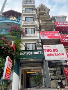 un edificio con carteles delante de una tienda en YÊN HÒA MOTEL, en Hanói