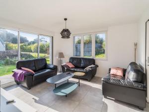 a living room with two leather couches and a table at Villa lumineuse 4 étoiles, 50m de la plage, jardin clos, tranquillité à Trégastel - FR-1-368-399 in Trégastel +3 photos