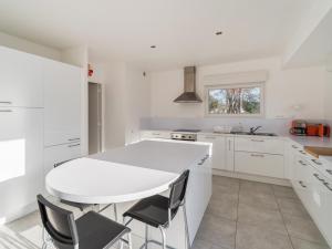 a white kitchen with a white table and chairs at Villa lumineuse 4 étoiles, 50m de la plage, jardin clos, tranquillité à Trégastel - FR-1-368-399 in Trégastel