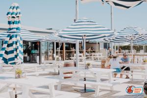 a group of white tables and blue and white umbrellas at Cervantes Lodge in Cervantes