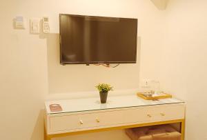 a flat screen tv on a wall above a dresser at UrbanView @ Stay Inn Style Hotel Vigan in Vigan