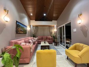 uma sala de estar com sofás cor-de-rosa e cadeiras amarelas em Makin' Memories em Kalimpong