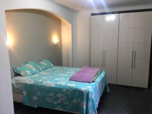 a small bedroom with a bed and a cabinet at Linda casa Assunção com Piscina Aquecida in Porto Alegre