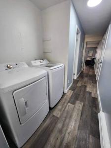 Freshly Renovated 2 bedroom unit في كورنوول: غرفة غسيل فيها غسالة ومجفف
