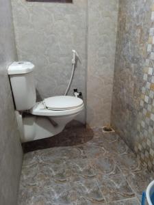 a bathroom with a toilet and a tiled floor at The Royal Inn in Visakhapatnam
