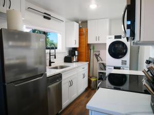 a kitchen with white cabinets and a stainless steel refrigerator at Private Studio - King Bed - Wifi in Arvada