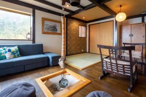 a living room with a blue couch and a table at ちどり庵 in Shio