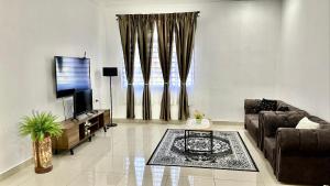 sala de estar con sofá y TV de pantalla plana en Mummy Firdhan Homestay en Rembau
