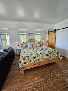 1 dormitorio con 1 cama con un edredón colorido en SeaSide Lake-Front Cottage en Madison