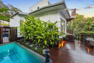 a house with a swimming pool in front of a house at Papillon Coolum in Coolum Beach