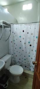 y baño con aseo y cortina de ducha. en Mini Departamento Iquitos 1243, en Iquitos