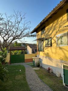 ein gelbes Haus mit einem Kiesweg daneben. in der Unterkunft By Búzios Loft in Búzios