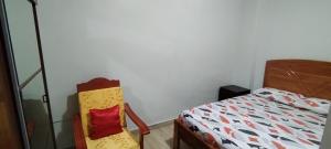 um quarto com uma cama e uma cadeira ao lado em Mini Departamento Iquitos 1243 em Iquitos