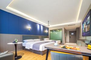 a hotel room with a large bed and a table at Suberun Hotel - Jinyang Street in Taiyuan