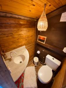 een badkamer met een wit toilet en een wastafel bij Pousada Paraíso das Tartarugas in Pipa