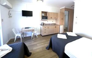 a room with two beds and a table and a kitchen at Accommodation @ 134 Denham in Townsville